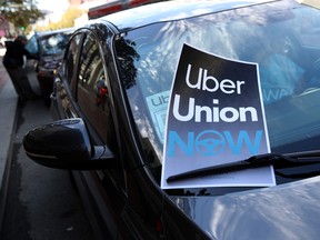 A sign in favour of a union for rideshare drivers sits on a car's windshield during a protest outside of Uber headquarters on August 27, 2019 in San Francisco, California.