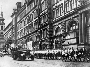 German Nazi troops and young Nazis parade in a street of Vienna in 1938 after the Anschluss, the invasion of Austria by the troops of the German Wehrwacht.