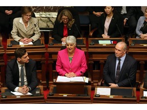 Attorney General David Eby and Premier John Horgan look on as Minister of Finance Carole James delivers the budget speech from the legislative assembly at B.C. Legislature in Victoria, B.C., on Tuesday, February 18, 2020.