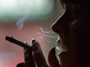 A woman smokes marijuana in an Amsterdam cafe. Ontario is considering the possibility of "consumption venues" as well as special occasion permits that would apply to outdoor festivals and concerts.