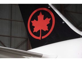 The Air Canada logo is shown on a plane at a hangar at the Toronto Pearson International Airport in Mississauga, Ont., on February 9, 2017. Spain's airport operator says an Air Canada plane is preparing to make an emergency landing at the Madrid airport. The authority, AENA, says in a tweet that the aircraft is returning to the runway due to technical problems.