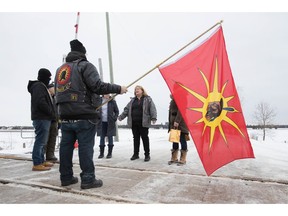 OPP Sgt. Diana Hampson of the liaison team, middle, speaks with members of the Mohawk Territory in Tyendinaga Mohawk Territory, near Belleville, Ont., on Tuesday, Feb. 11, 2020. The members have blocked the CN/VIA train tracks for six days in support of Wet'suwet'en's blockade of natural gas pipeline in northern B.C.