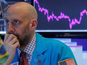 A trader works at his post on the floor at the New York Stock Exchange on Monday. Wall Street dived around 3 per cent on open.
