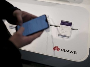 An employee demonstrates a Huawei smartphone at a Telus Corp. store in Toronto. Telus says it will launch a 5G network in Canada this year using Huawei equipment.