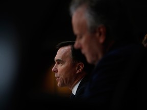 Bill Morneau, Canada's minister of finance, left, speaks while Stephen Poloz, governor of the Bank of Canada, listens during a news conference in Ottawa, Wednesday.