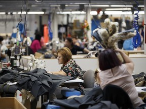 Employees work at sewing stations inside the Canada Goose production facility in Toronto, in 2017.
