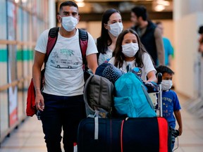 Travellers wear face masks at an airport in Santiago, Chile.