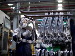An employee wearing a face mask works on a car seat assembly line at Yanfeng Adient factory in Shanghai, China.