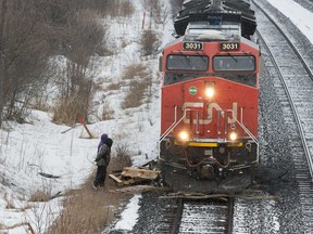 A Canadian National Railway train moves through wooden pallets placed there by occupants of a Tyendinaga Mohawk Territory encampment set up in support of the Wet'suwet'en Nation who are trying to stop construction of British Columbia's Coastal GasLink pipeline, in Tyendinaga, Ontario, on Feb. 26, 2020.