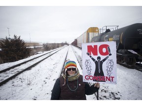 A protester holds a placard as supporters of the Wet'suwet'en hereditary chiefs demonstrate at Macmillan Yard in Toronto, Saturday, Feb. 15, 2020. In the last month, Indigenous people across the country set up barricades on train tracks, roads and bridges, in solidarity with Wet'suwet'en Nation hereditary chiefs, some of whom object to the construction of a natural-gas pipeline through their traditional territory.