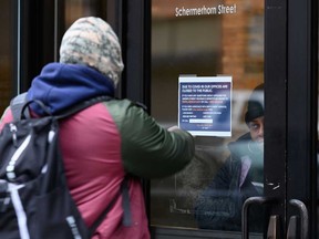 A person points at a sign in front of the closed Department of Labor in New York. U.S. unemployment claims rise 3.3 million for the week of March 21, 2020.