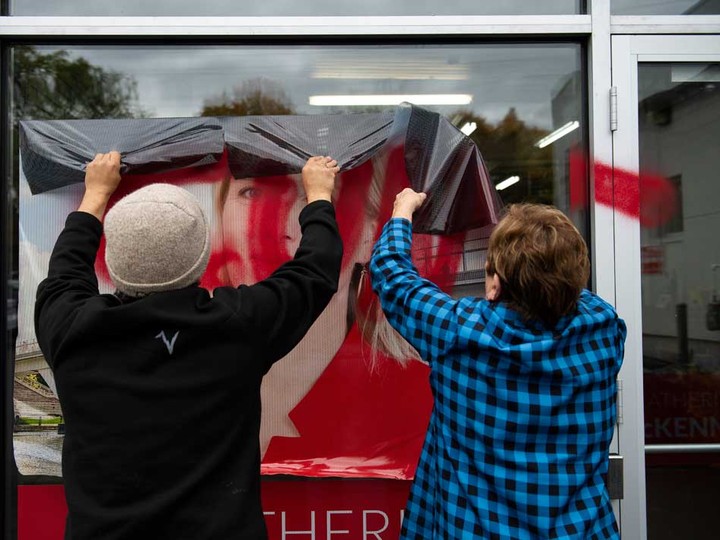  Campaign team members remove a window decal that was defaced with a misogynistic slur on the campaign office of Liberal MP Catherine McKenna, in Ottawa last October.