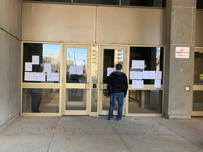 Notices about changes to the Ontario justice system scheduling because of COVID-19 plaster the front doors of the London, Ont., courthouse.