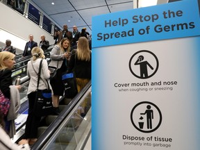 Visitors pass a sign warning about the spread of germs at the Prospectors and Developers Association of Canada (PDAC) annual conference in Toronto.
