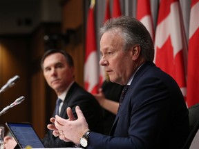Bank of Canada Governor Stephen Poloz, right, and Finance Minister Bill Morneau, left, speak during a news conference on Parliament Hill March 18, 2020 in Ottawa.