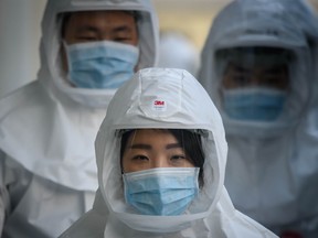 In this photo taken on March 12, 2020, medical workers wearing protective clothing against the COVID-19 novel coronavirus walk to a decontamination area at the Keimyung University hospital in Daegu, South Korea.