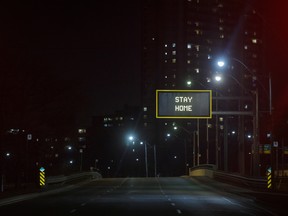 "Stay Home" is displayed on a sign over an empty road in Toronto.