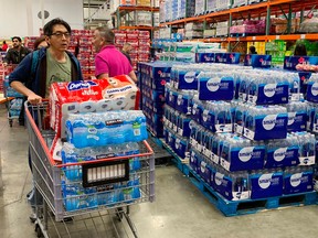 People buy water, food and toilet paper at a store, as they begin to stockpile essentials from fear that supplies will be affected by the spread of the COVID-19, coronavirus, outbreak across the country, in Los Angeles, California on February 29, 2020.