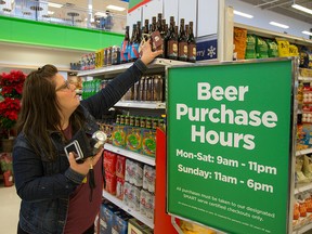 Erin Anderson looks over a selection of craft beers at the Oakridge Superstore in London, Ont., in a file photo from Dec. 15, 2015.