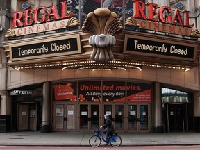 A man cycles past a shuttered movie theatre in Times Square following the outbreak of coronavirus disease  in the Manhattan borough of New York City.