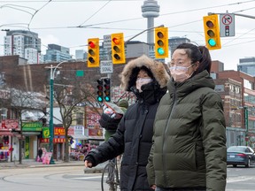 Women in downtown Toronto's Chinatown wear protective masks on Jan. 27, 2020.