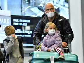 Travellers, wearing masks, arrive on a direct flight from China, at Vancouver International Airport in January.