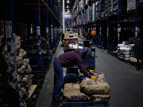 A worker loads bags of produce onto a forklift at a Kroger Co. grocery distribution center in Louisville, Kentucky, U.S., on Friday, March 20, 2020.