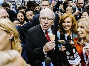 Warren Buffett, chairman and chief executive officer of Berkshire Hathaway Inc., center left, eats a Dairy Queen vanilla orange ice cream bar while touring the shopping floor ahead of the company's annual meeting in Omaha, Nebraska, U.S., on Saturday, May 4, 2019.