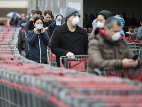 Hundreds of people wait in line to enter Costco in Toronto on Monday, April 13, 2020.