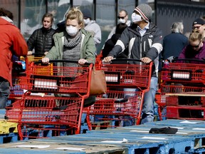 Due to COVID-19, shoppers line up in front of Loblaws, separated in rows by stacked wooden pallets on Thursday April 9, 2020 at the Leslie St location in Toronto.