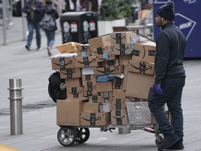 An Amazon delivery person walks in Times Square following the outbreak of COVID-19, in the Manhattan borough of New York City.