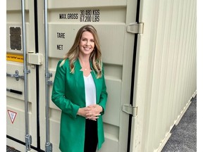 Amy Thompson, President & co-Founder of Northern Container Sales, stands in front of a shipping container.