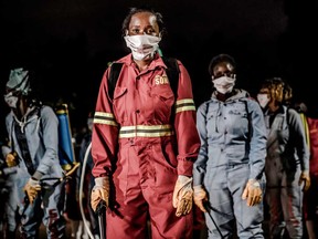 Members of a privately-funded NGO working with county officials wearing protective gear fumigate and disinfect the streets and stalls of a market in Nairobi during the dusk-to-dawn curfew imposed by the Kenyan Government.