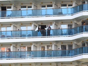 Passengers aboard the Costa Luminosa cruise ship, that was hit by the coronavirus disease, wave from a balcony, at the port of Savona, near Genoa, in Italy, on March 21, 2020.