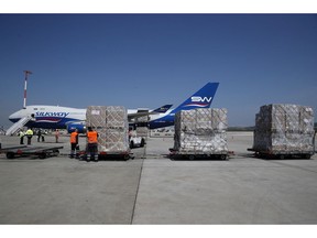 Workers unload a cargo plane at Eleftherios Venizelos International Airport in Athens, Tuesday, March 31, 2020. Scores of countries have moved to restrict the export of face masks, gloves and other medical supplies critical for front-line workers in the fight against the COVID-19 pandemic, leaving Canada and other states scrambling to source products that now have higher price tags.THE CANADIAN PRESS/AP Photo-Thanassis Stavrakis