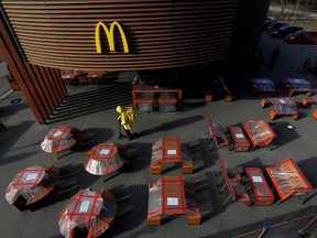 A food delivery courier rides a scooter among plastic-wrapped tables of McDonald's restaurant, as the spread of the coronavirus disease (COVID-19) continues, in Saint Petersburg, Russia March 28, 2020.