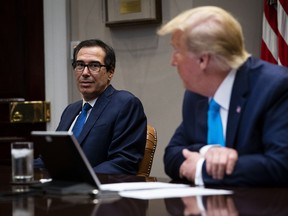 U.S. President Donald Trump and Treasury Secretary Steven Mnuchin, left, participate in a video conference with representatives of large banks and credit card companies about more financial assistance for small businesses in the Roosevelt Room at the White House April 7, 2020 in Washington, D.C.