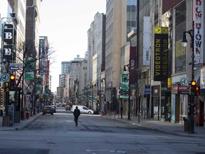 A pedestrian walks down an empty Saint-Catherine Street in Montreal in March.