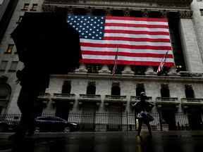 In this file photo a woman walks past the New York Stock Exchange (NYSE) on March 19, 2020 at Wall Street in New York City.