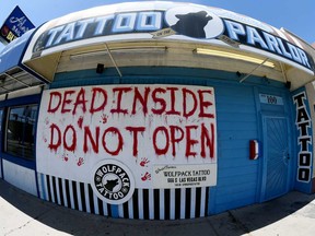 A sign posted outside Wolfpack Tattoo Las Vegas reads "Dead inside do not open" in a reference to the pilot episode of "The Walking Dead" television series as nonessential businesses remain closed due to the continuing spread of the coronavirus on April 28, 2020 in Las Vegas, Nevada.
