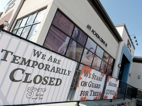 Temporarily closed signs are seen posted on Esthetic Spa & Salon in Calgary because of the COVID-19 pandemic.