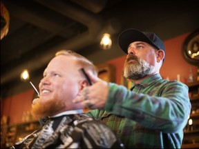 Jason Zalusky, owner of Bluecore Barber Co. in Regina, tends to a customer.