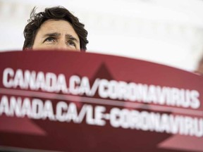Prime Minister Justin Trudeau speaks from behind a podium bearing the hyperlink to a federal government website about the coronavirus disease during a press conference about COVID-19.