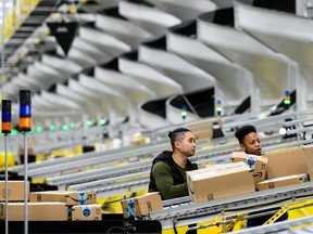 Men work at a distribution station in the 855,000-square-foot Amazon fulfillment center in Staten Island, one of the five boroughs of New York City, on February 5, 2019.