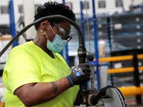 A Dana Inc. assembly technician wears a face mask as she assembles axles for automakers, as the auto industry begins reopening amid the coronavirus disease (COVID-19) outbreak, at the Dana plant in Toledo, Ohio on May 18.