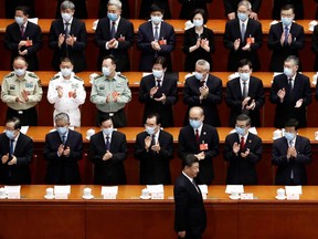 Chinese President Xi Jinping walks past officials wearing face masks as he arrives for the second plenary session of the National People's Congress at the Great Hall of the People in Beijing on Monday.