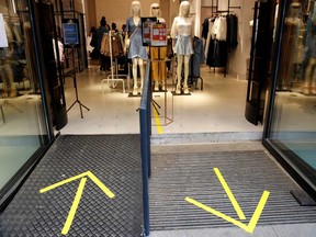 Yellow arrows mark the entrance and exit on the reopening day of a woman's clothing store
