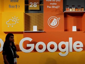 A woman walks past the logo of Google during an event in New Delhi, India. India's antitrust body is looking into allegations that Alphabet Inc's Google is abusing its market position.