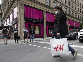 A pedestrian wearing a protective mask carries an H&M shopping bag in Montreal, Quebec.