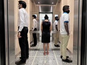 People practice social distancing inside an elevator on their way to work. If employers are negligent in preparing and enforcing their employees’ return-to-work protocols, they risk massive civil liability or Workplace Safety and Insurance Board claims from employees who attend work and are infected, writes Howard Levitt.